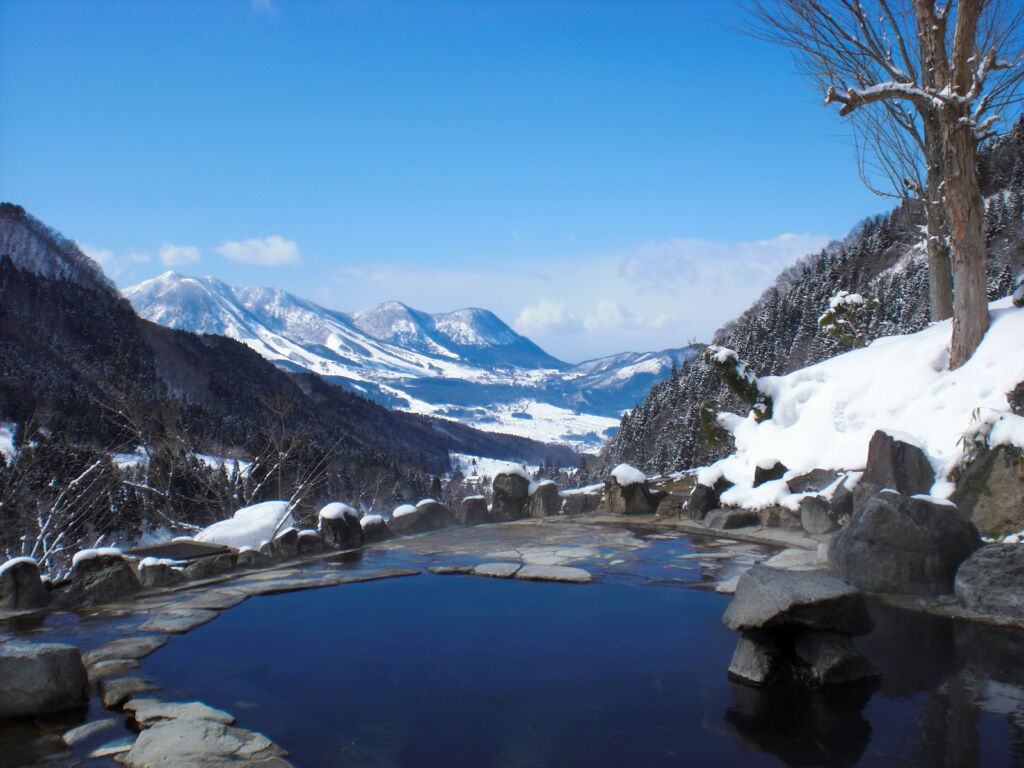 Outdoor onsen with mountain panorama and snow, Nozawa Onsen