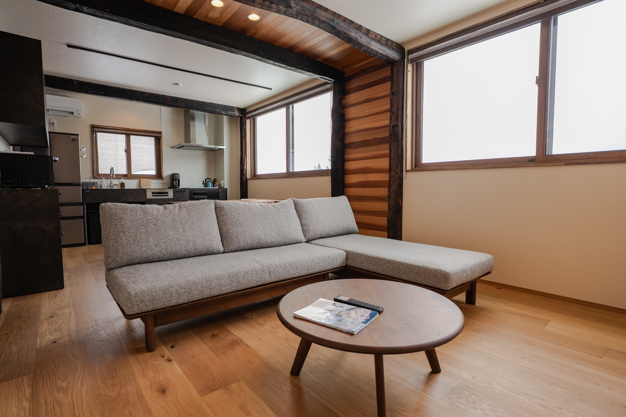 Light-filled living space with chaise sofa and open kitchen