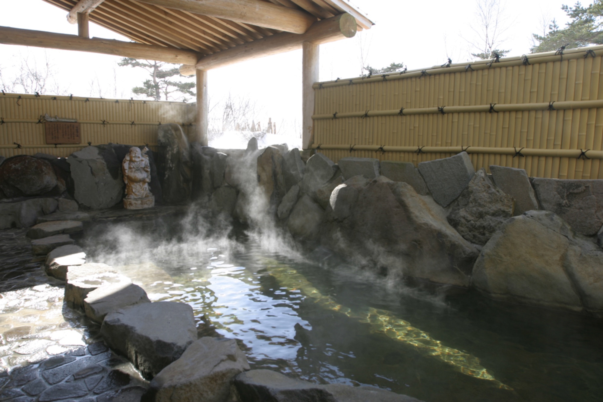 Steam rising from a traditional outdoor onsen